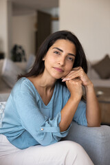 Obraz premium Positive thoughtful beautiful Latin woman leaning head on hands