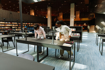 Two female students sit down at the tables