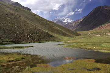 Mountain lake. A lake formed by a small mountain river between the mountains. Small mountain lake surrounded by green vegetation