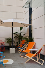 A Chic Outdoor Lounge Area Featuring Colorful Deck Chairs and a Welcoming Umbrella for Relaxation