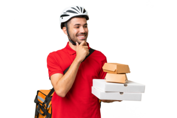 Young handsome caucasian man with thermal backpack and holding takeaway food over isolated background looking to the side and smiling