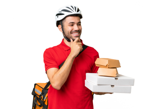 Young handsome caucasian man with thermal backpack and holding takeaway food over isolated background looking to the side and smiling