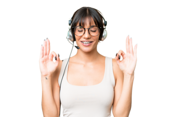 Telemarketer caucasian woman working with a headset over isolated background in zen pose