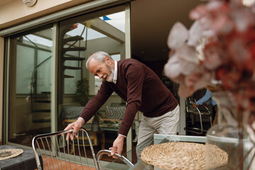 A man stands and moves a chair to the table