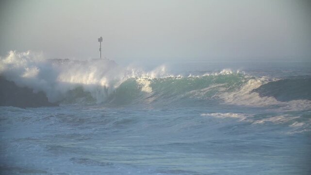Huge waves breaking on the rock jetty