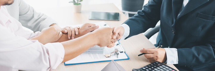 Panorama of successful real estate deal with handshake, contract, house key and calculator on desk,...