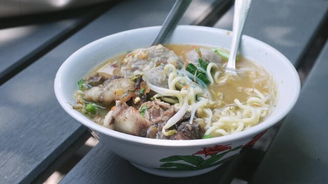 Close up of a Mie Bakso (meatballs with noodle soup) one of the most Indonesia popular street food. Besides noodles and meatballs, it is also served with bean sprouts and pieces of beef cartilage