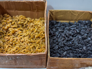 Two boxes with different types of raisins golden raisins and black raisins. 