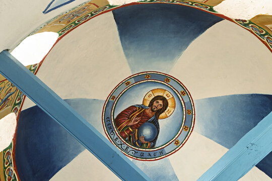 ornately decorated ceiling featuring a triangular architectural element with a circular medallion in a church of Olympos, Karpathos Island, Greece,
