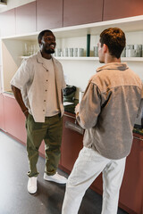 Obraz premium A male worker is smiling and talking to a male worker standing across from him