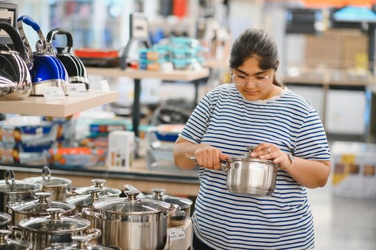 Indian woman buying pan in shop cookware