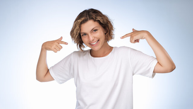 A woman in a white tshirt is flexing her arm muscles