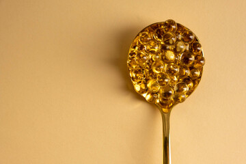 Capsules of vitamin D3 on a yellow background with free space. Biologically active substances of the calciferol group are fat-soluble organic compounds.