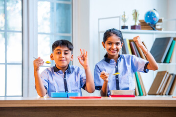 Indian students enjoy lunch break, sharing tiffin laughter in classroom wearing school uniforms