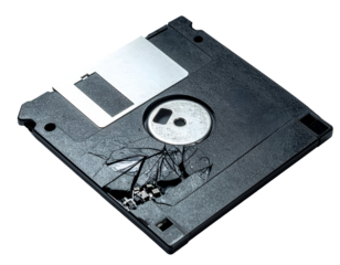 Broken vintage floppy disk with cracked shell and exposed magnetic platter retro data storage on isolated background