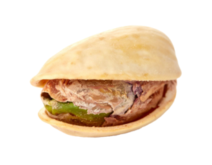 Pistachio nut with open shell, showing green kernel and partially cracked outer skin, roasted snack food on transparent background