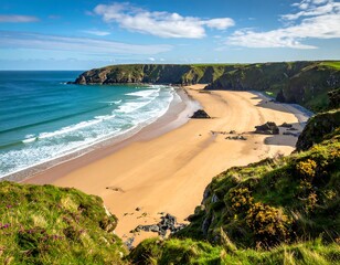 Aerial view of an ocean beach with golden sand, emerald water, and verdant cliffs under a blue sky with clouds