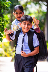 Indian School Kids in Uniform Flaunting Trophy Proudly While Standing Outside and Looking at Camera