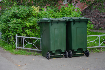 Two garbage cans are near the house
