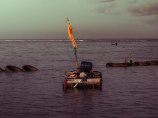 A lone homemade boat floating on the open sea, creating a quiet and minimalist coastal scene.

