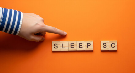 Hand pointing at wooden blocks spelling sleep science on orange background, emphasizing the importance of sleep and scientific research