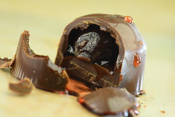 Chocolate candy with liqueur filling on a light background, macro, close-up.