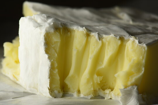Soft French brie cheese, cut, soft filling close-up.
