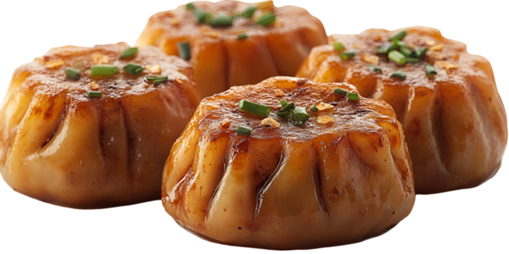 Closeup of several golden baked dumplings against a transparent background