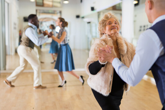Mature woman learning to dance lindy hop with younger man