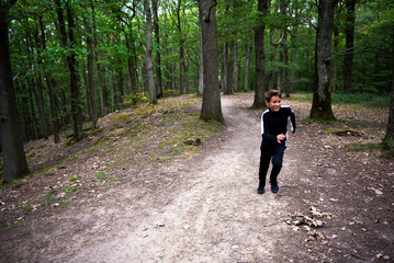Fototapeta premium jeune garçon courant dans la forêt, détente et sport