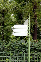 There is a pole with arrows pointing in the park.