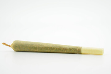 A joint after rolling, with a paper filter at left marijuana cigarette. Joint rolled cannabis cigarette, Prerolled Stick real photo white background
