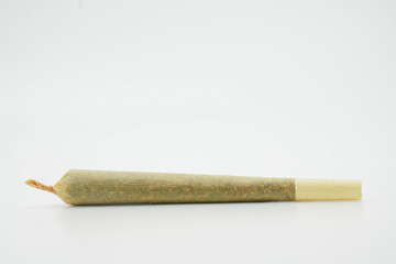 A joint after rolling, with a paper filter at left marijuana cigarette. Joint rolled cannabis cigarette, Prerolled Stick real photo white background