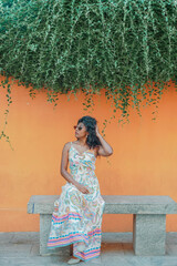 Obraz premium A woman is sitting on a bench wearing a white dress