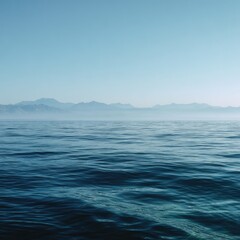 Fototapeta premium Calm ocean meets hazy mountain range