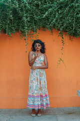 Obraz premium A woman in a colorful dress stands in front of a wall