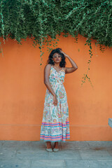 Fototapeta premium A woman in a white dress is posing in front of a wall