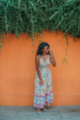 Obraz premium A woman in a colorful dress stands in front of a wall