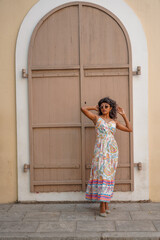 Fototapeta premium A woman in a white dress stands in front of a building with a doorway