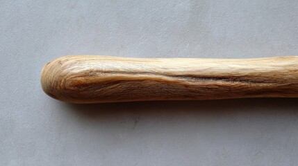 Close-up of a wooden stick or handle. the stick appears to be made of a light-colored wood, possibly pine or oak, with a smooth and polished surface.