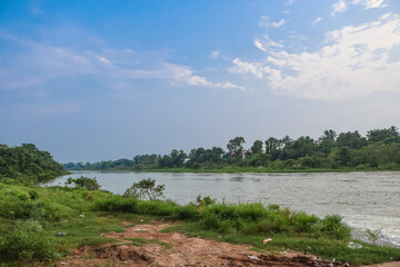 Beautiful lake and nature landscape. Flowing water surrounded with trees.
