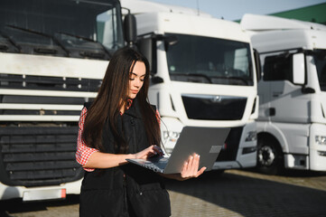 Obraz premium Portrait of a beautiful woman truck driver standing in the parking lot