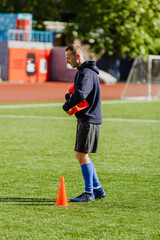 Fototapeta premium A man walks and carries soccer cones