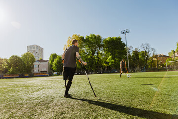 Two men on crutches run towards a ball between them