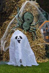 Festive halloween decor scene with Ghost, Spider and
Hay Bales