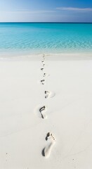 Footprints on White Sand Beach Leading to Turquoise Sea.