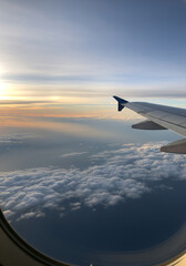 Obraz premium Golden Sunset or Sunrise Light Over Clouds Seen from Aircraft Window