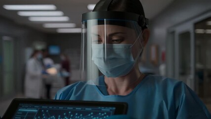 Female doctor in ppe using tablet with medical data - Powered by Adobe
