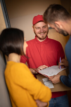 Couple receiving package from delivery person.