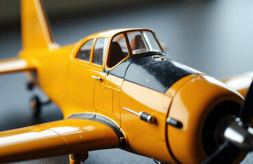 Obraz premium A close-up of a yellow and black model airplane with detailed features and a blurred background